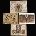 Collection of vintage pfennig german notgeld banknotes with intricate designs and text on a dark fabric background.