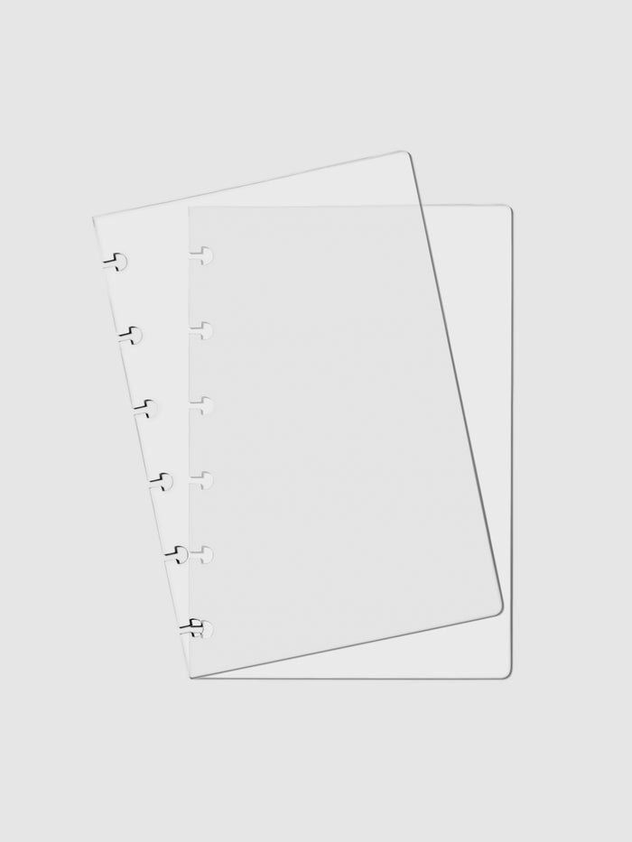 Crystal Clear Discbound Notebook Cover, CP Petite, Cloth and Paper. Two transparent notebook covers laid on top of one another with the top cover tilted slightly to the left.