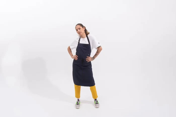 Person wearing a navy blue apron over a white shirt on a white background